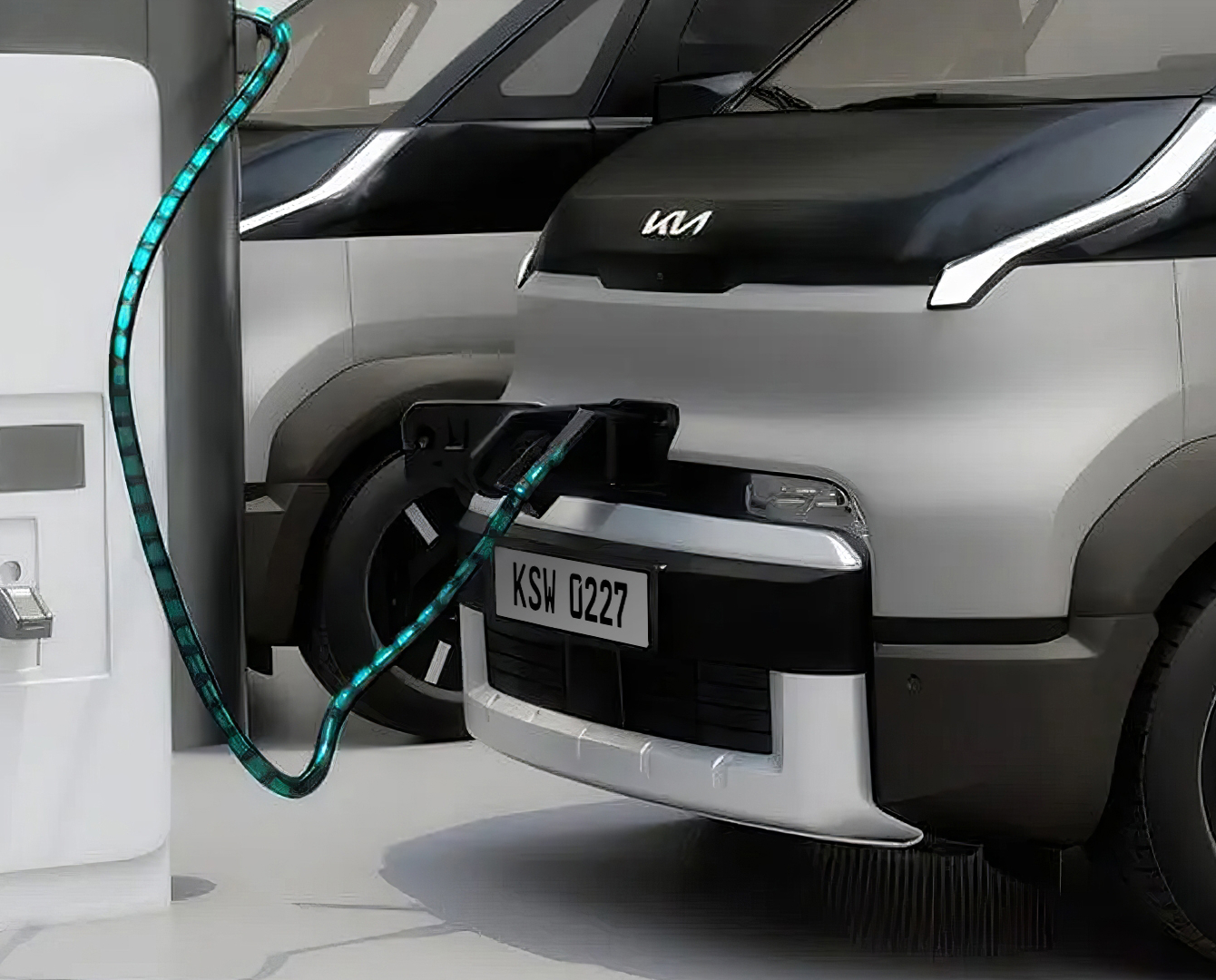 Partial front view of the Kia PV5 Cargo connected to charging station
